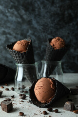 Black cones with ice cream against dark background