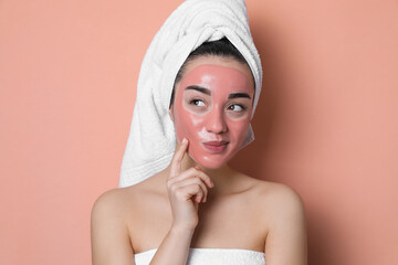 Woman with pomegranate face mask on pale coral background