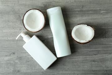 Shower gels and coconut on gray textured background