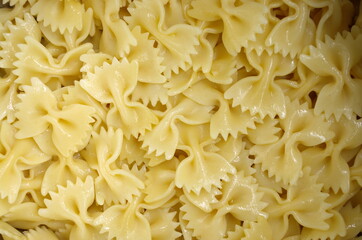 Coocked italian pasta farfalle with oilve oil top view. Texture of Italian pasta macaroni bows farfalle. Close up. Background carbohydrates food.