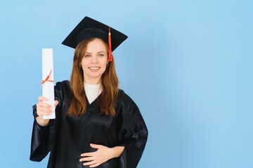 Woman graduate student wearing graduation hat and gown, on blue background