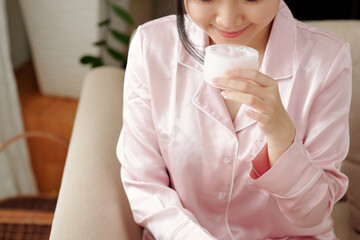 Young woman smiling when smelling new boy lotion she is going to apply