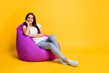 Full length body size photo of pretty brunette chilling in violet beanbag on pause isolated on...
