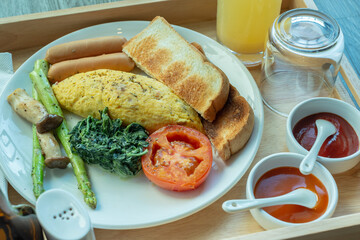 omelet breakfast set serve with sausage, toast bread, vegetables 