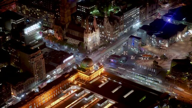 Night timelapse with of Flinders Station, Paul Cathedral and Federation Square of Melbourne City filled with movements from pedestrians, traffics, and trams from Eureka Tower on loop.