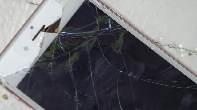Close Up On A Smashed White and Pink Smartphone On The Floor