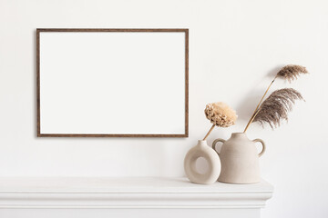 Blank picture frame mockup in home interior design. Living room, commode with lamp and vases. View...