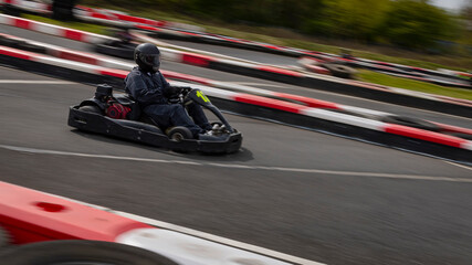 A panning shot of a racing kart as it circuits a track.