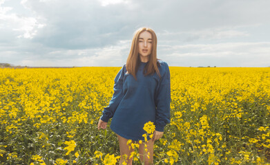 Fototapeta premium beautiful girl in blue hoodie in yellow field
