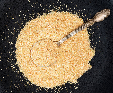 silver tablespoon in amaranth grain on black plate