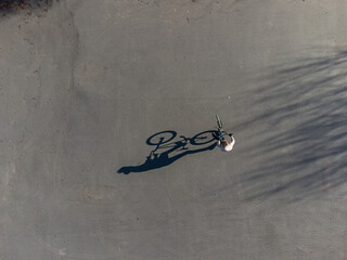 Top view of long shadow of a man on a bicycle on the asphalt. Street sport concept