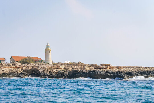 Coastline with a lighthouse and outbuildings on the coast in Cyprus
