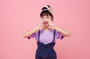 Happy Asian child shout story or making announcement isolated on pink background.