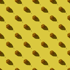 Seamless pattern on a yellow background from ripe pears, top view.Background with pears.