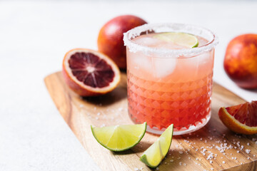 Blood orange margarita cocktail on white table background. Summer cocktails, refreshing drinks, cocktail party concept. Close up, copy space