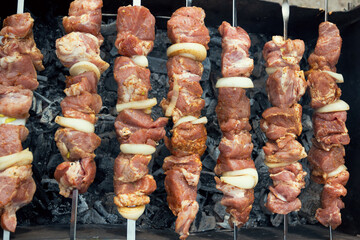 Marinated shashlik preparing on a barbecue grill over charcoal. Shashlik or Shish kebab popular in Eastern Europe. Shashlyk (skewered meat) was originally made of lamb. Roast Beef Kebabs On BBQ Grill.