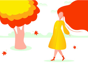 Autumn mood. A woman with long red hair walks past a tree with orange leaves