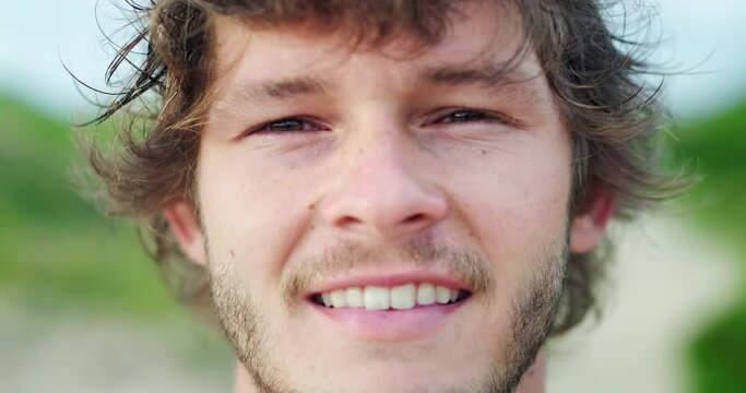 Close up portrait of young Brazilian man on the beach. Brazilian surfer stands outdoor, close up portrait