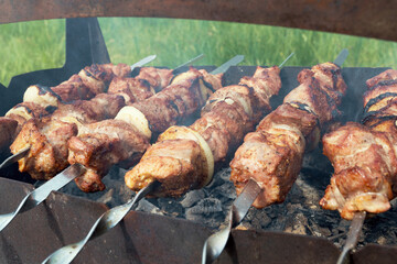 Marinated shashlik preparing on a barbecue grill over charcoal. Shashlik or Shish kebab popular in Eastern Europe. Shashlyk (skewered meat) was originally made of lamb. Roast Beef Kebabs On BBQ Grill.