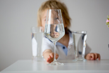 Sweet toddler boy, drinking water at home