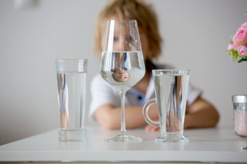 Sweet toddler boy, drinking water at home