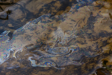 oil spills on puddle background, abstract gasoline nature pollution concept
