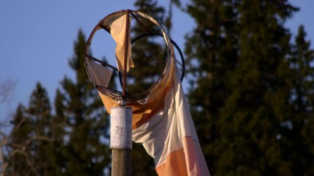 Broken Windsock Against Bokeh Tree Foliage At Airport Runway. - Close Up Shot