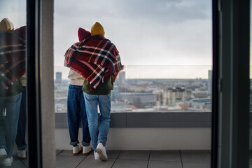 Obraz premium Rear view of young couple owners on balcony in new flat, moving in, new home and relocation concept.