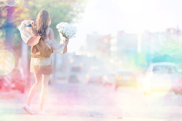 girl waiting for a city date / happy girl with a bouquet of flowers walking in the urban landscape, soft light