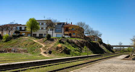 Fototapeta na wymiar View of railroad tracks and solitary train station platform in the town of La Bañeza, Spain.