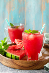 Summer cold drink. Refreshing Watermelon drink in glasses and slices of watermelon on a stone tabletop. Copy space.