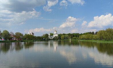 Fototapeta na wymiar Gomel, Belarus - May 16, 2021. The lake is a park area next to the Temple of the Holy Blessed Prince Alexander Nevsky.