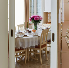 table setting a table in the living room set for tea with flowers in front of the window