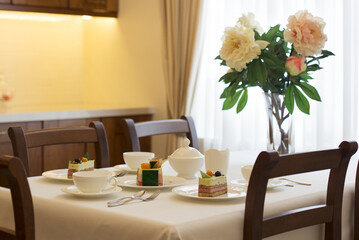 table setting a table in the living room set for tea with flowers in front of the window