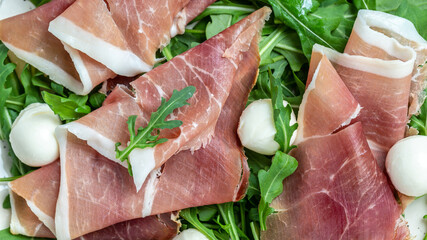 Antipasto salad with prosciutto, mozzarella cheese and arugula, Antipasti, a traditional Italian, Food recipe background. Close up