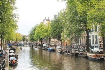 Canal in Amsterdam. Boats, water, trees, reflections. 