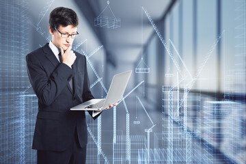 Smart city background with pensive architect with laptop on virtual wall background with digital building layout.