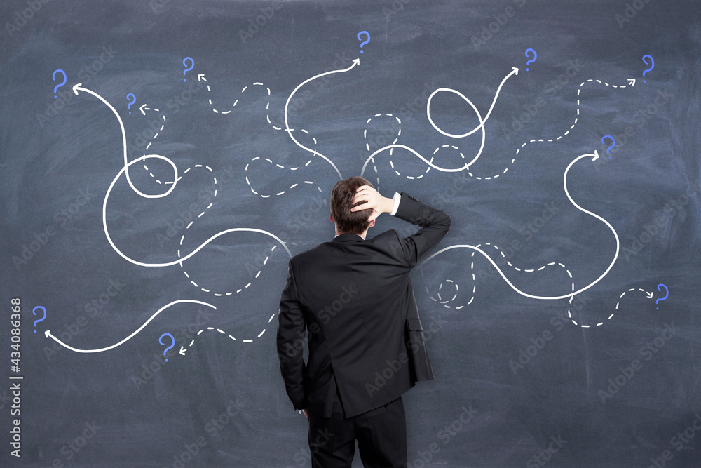 Poster Right decision concept with man in black suit looking at chalkboard with painted dotted curved lines with question marks.