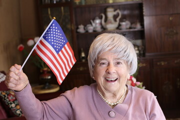 Senior woman holding the American flag at home