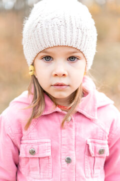portrait of a sad caucasian little girl in a knitted hat