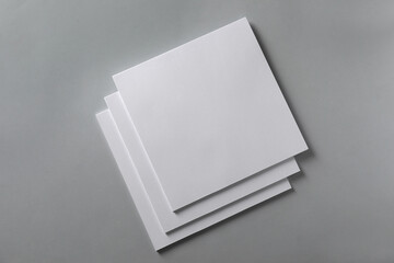 Stack of blank paper sheets for brochure on light grey background, top view