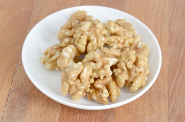 walnuts on a white plate in a wooden table