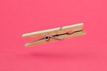 Wooden cloth peg over pink background