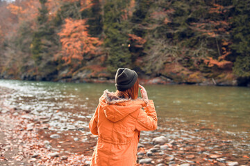 Fototapeta na wymiar cheerful woman Tourist in a jacket Autumn forest river nature