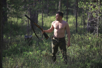 man goes hunting forest summer / landscape in the forest, huntsman with a hunting rifle hunts