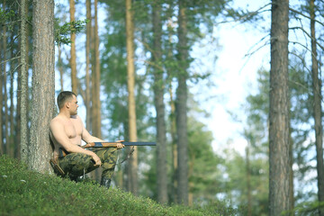 Obraz premium man goes hunting forest summer / landscape in the forest, huntsman with a hunting rifle hunts