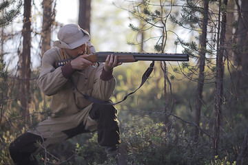 Naklejka premium man goes hunting forest summer / landscape in the forest, huntsman with a hunting rifle hunts