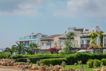 Fototapeta na wymiar Modern villas with manicured green lawns by the sea