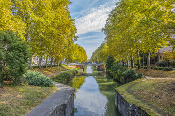 Obraz premium Beautiful autumn views of Canal du Midi (in XVII century - Royal Canal in Languedoc) in Toulouse and trees reflection in water. Toulouse, Haute-Garonne, France.