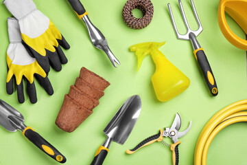 Fototapeta na wymiar Flat lay composition with gardening tools on green background